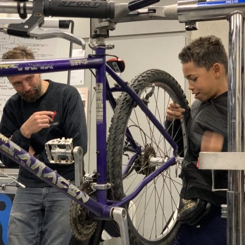Young people fixing bikes with Bikeworks